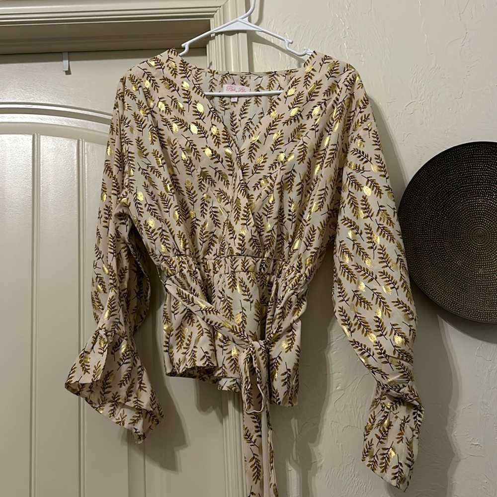 Tan peplum top with gold accents